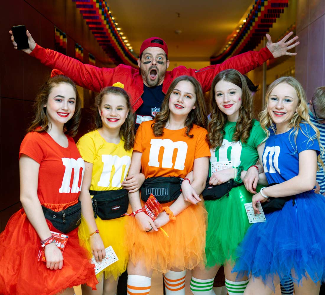 Gruppe Mädchen im M&M Kostüm